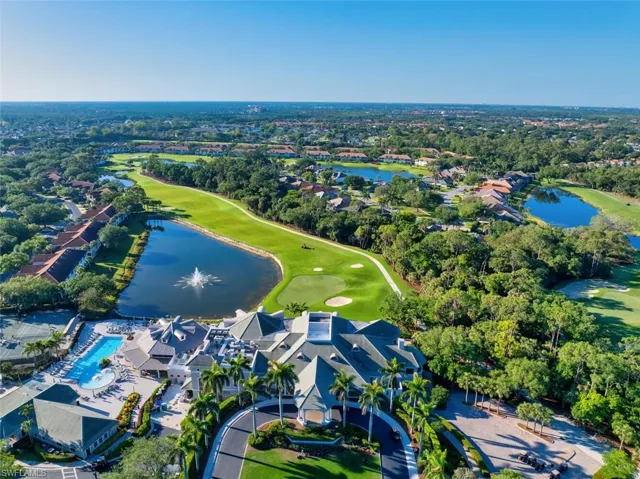 Aerial overview of property's location with a nearby body of water, a golf course, a tree filled landscape