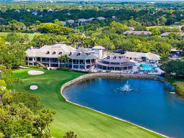 Bird's eye view of a nearby body of water, a golf club, and a tree filled landscape