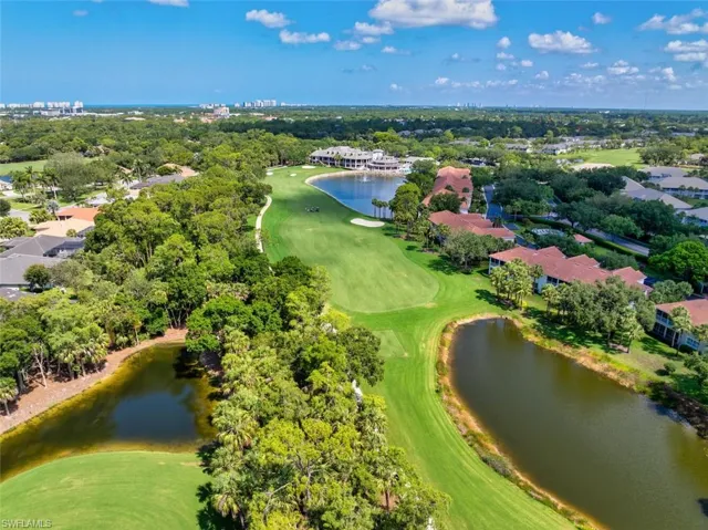 Aerial perspective of community with golf course, lake, and a tree filled landscape