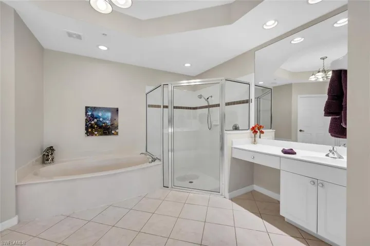 Bathroom with a garden tub, tile patterned floors, vanity, a shower stall, and a tray ceiling