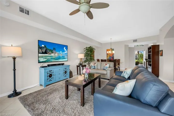 Living area featuring ceiling fan, a chandelier,  and light tile patterned floors