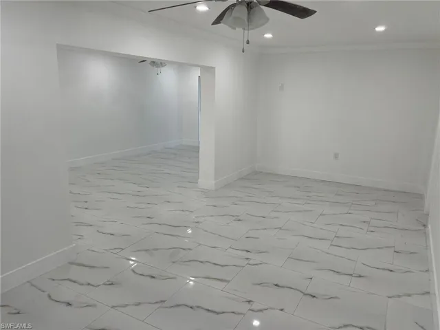 Spare room with light marble finish floors, ornamental molding, recessed lighting, and a ceiling fan