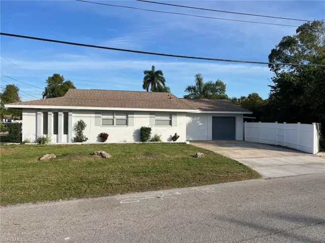 Ranch-style home with stucco siding, driveway, an attached garage, and roof with shingles