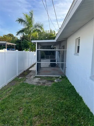Fenced backyard featuring a sunroom and a patio