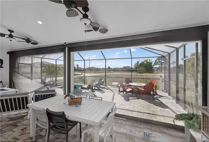 View of patio featuring outdoor dining area, electric hurricane downs on lanai