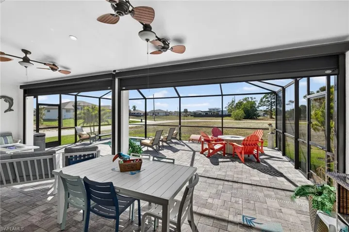 View of patio featuring outdoor dining area, electric hurricane downs on lanai