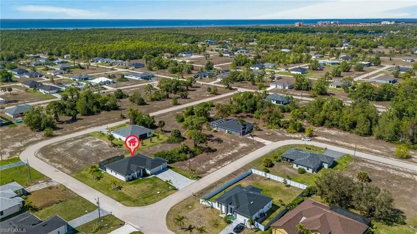 Aerial view of property and surrounding area featuring nearby suburban area