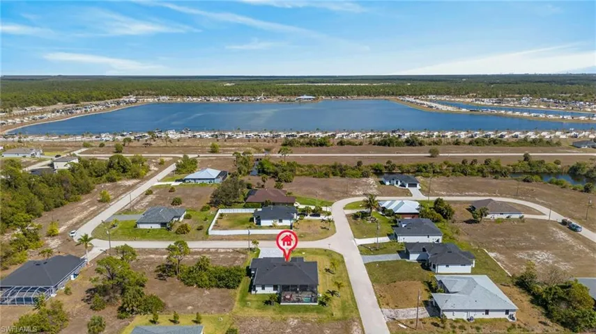 Aerial view of property and surrounding area with nearby suburban area and a nearby body of water