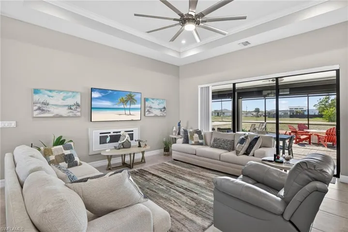 Living area with a ceiling fan, high ceilings, and recessed lighting