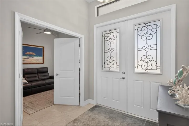 Entrance foyer featuring double entry doors, a ceiling fan and light tile floors