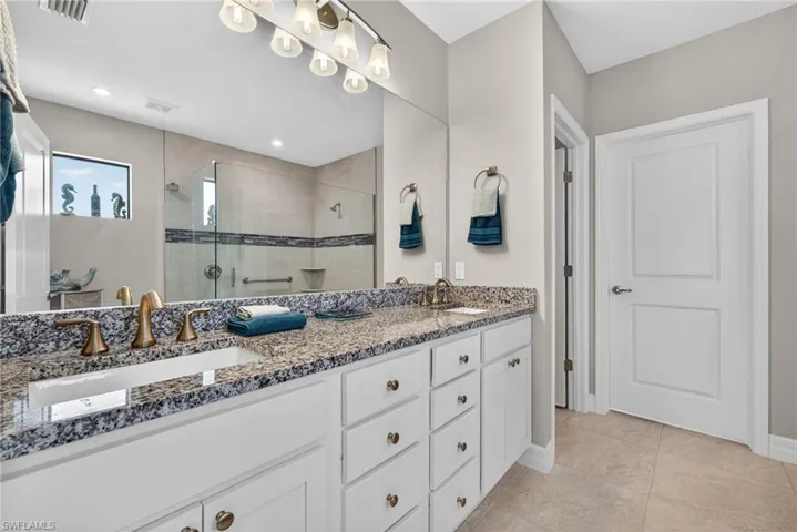 Full bathroom featuring double vanity, and light tile floors