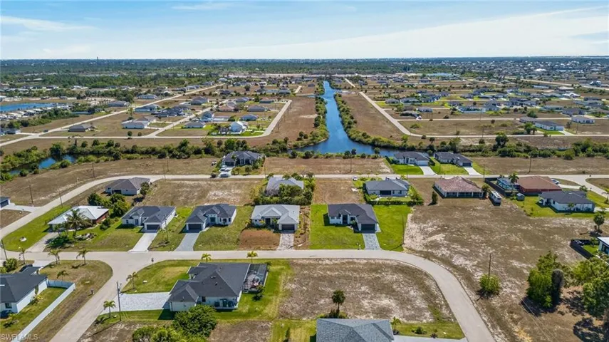 Aerial view of property and surrounding area with nearby suburban area and a large body of water