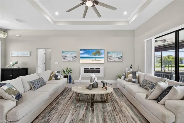 Living room with ceiling fan, a fireplace and large tiled floors