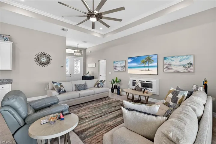 Living area featuring  ceiling fan, and a raised ceiling