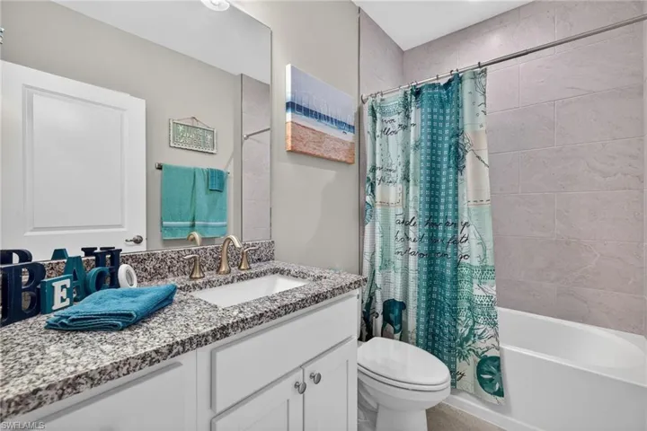 Bathroom featuring vanity and shower / bath combo with shower curtain