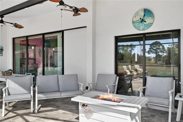 View of patio lanai  featuring an outdoor living space with a fire pit and a ceiling fan