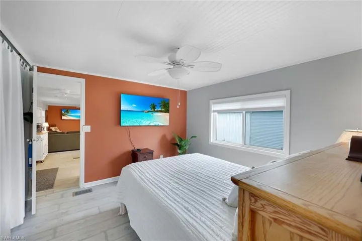 Wood-finish flooring, ceiling fan, and built-in window with blinds