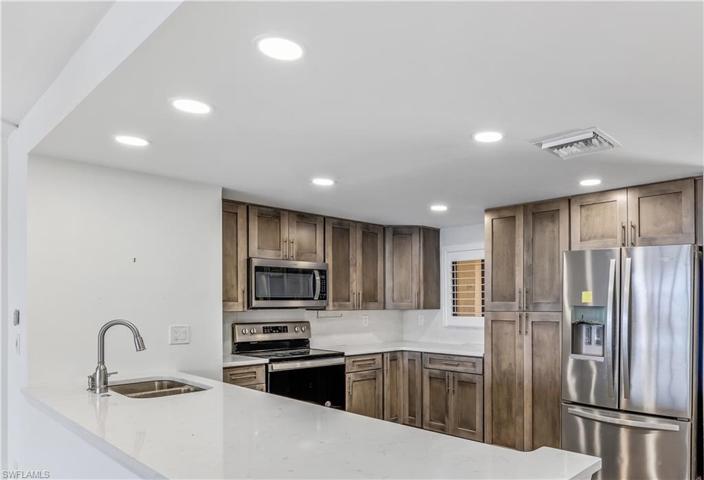 Kitchen with Quartz, Wood Cabinets, And Stainless Appliances