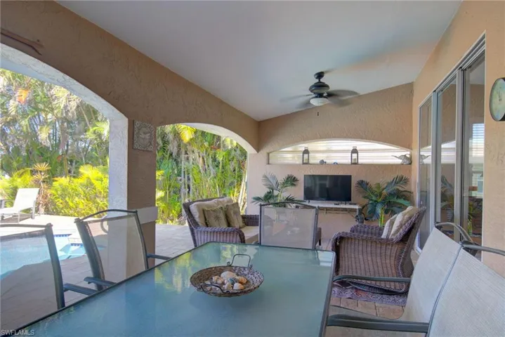 View of patio / terrace with a fenced in pool, outdoor dining space, and a ceiling fan
