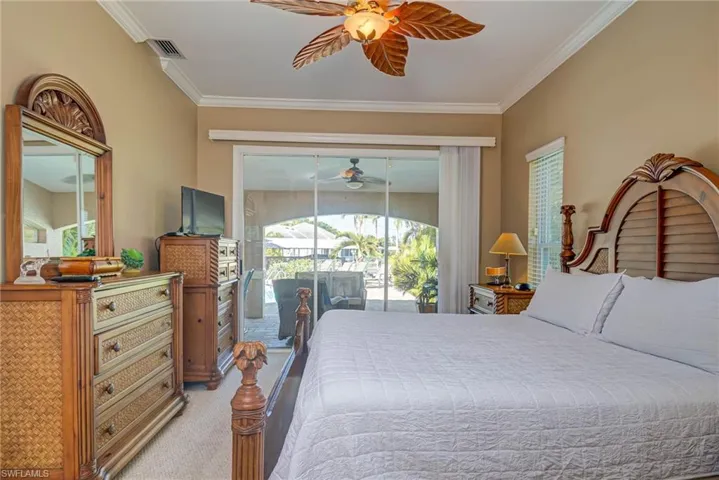 Bedroom with visible vents, carpet, ornamental molding, a ceiling fan, and access to exterior