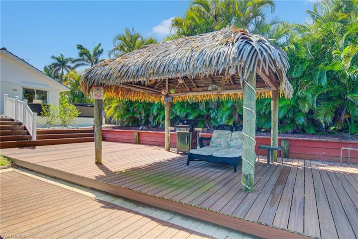 Wooden terrace featuring a gazebo and a grill