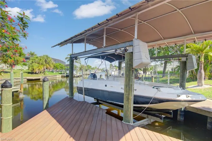 View of dock with boat lift and a water view