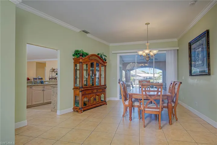 Dining area featuring baseboards, crown molding, a chandelier, and light tile patterned floors