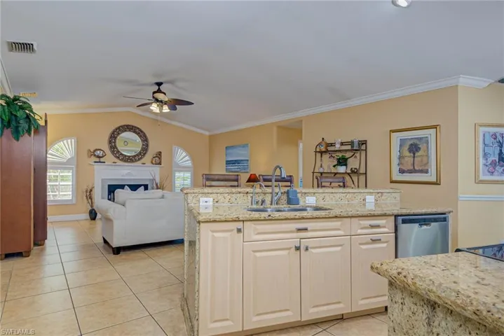 Kitchen with crown molding, a sink, a ceiling fan, dishwasher, and visible vents