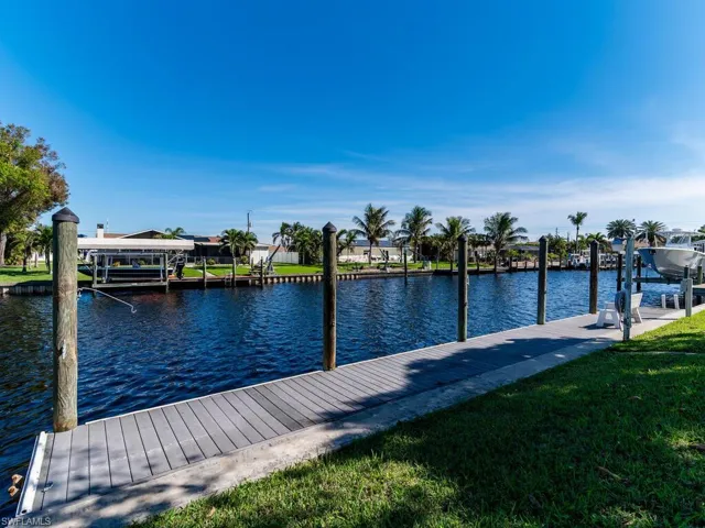View of dock featuring a water view and a lawn