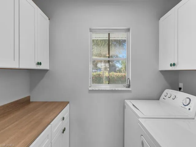 Washroom featuring cabinets and washer and dryer