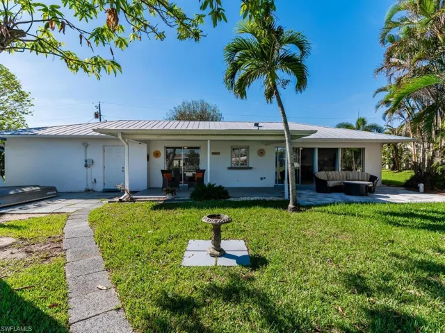 Single story home featuring an outdoor living space and a front lawn