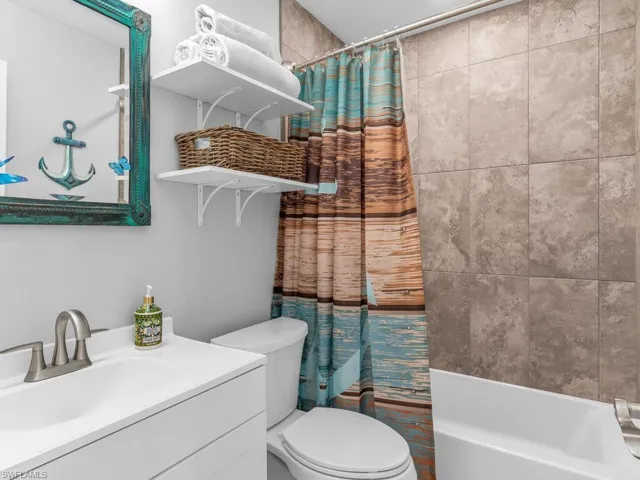 Full bathroom with vanity, shower / bath combo, and toilet