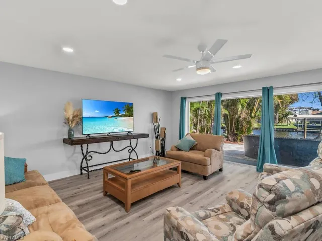 Living room with ceiling fan and light wood-type flooring