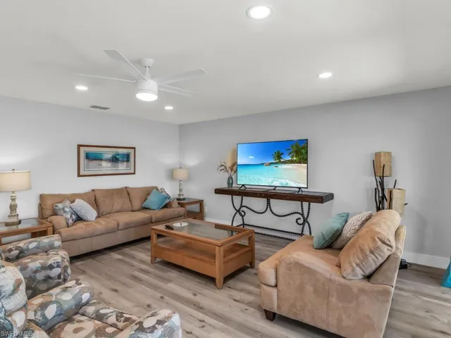 Living room with ceiling fan and light hardwood / wood-style floors