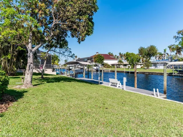 Dock area with a water view and a yard