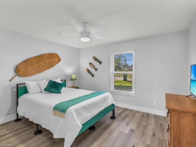 Bedroom with ceiling fan and light wood-type flooring