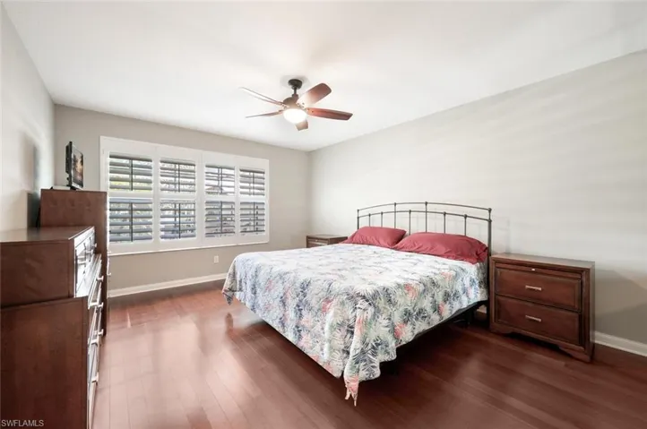 A Spacious Master Bedroom with Planation Shutters and Pool/Lake Views.