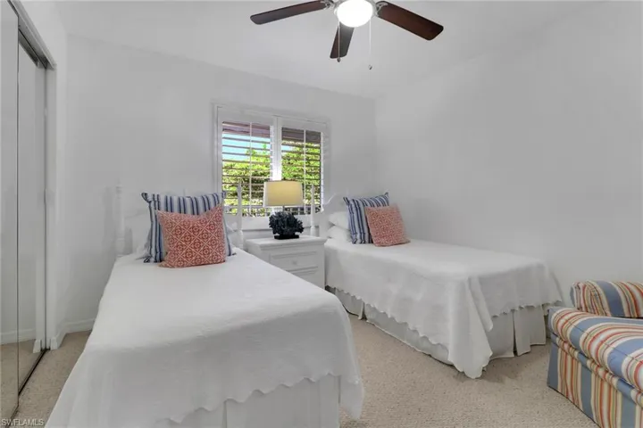 Bedroom featuring a closet, light carpet, and ceiling fan