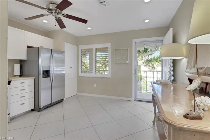 Kitchen featuring white cabinetry, light countertops, stainless steel fridge with ice dispenser, light tile patterned flooring, and recessed lighting