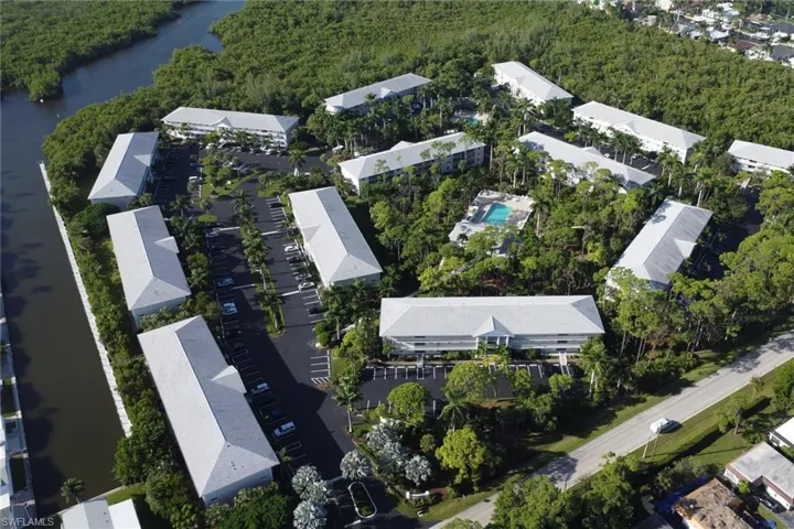 Aerial view of property's location featuring a nearby body of water and a heavily wooded area