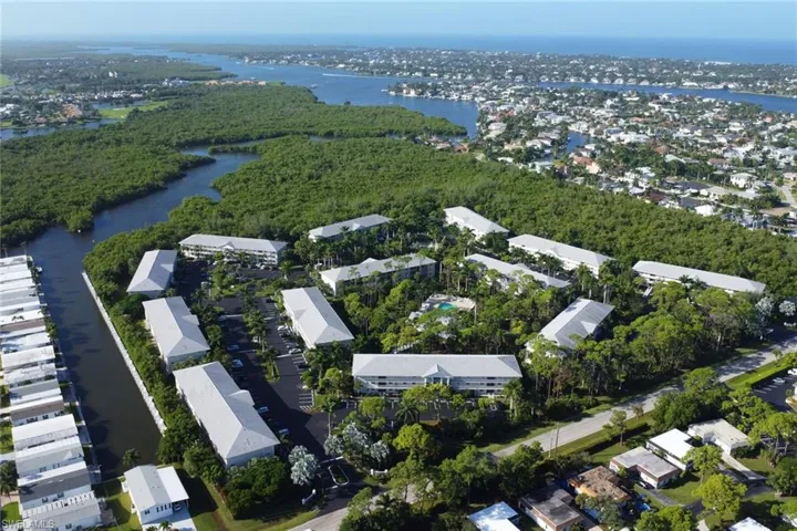 Aerial view of property's location featuring a nearby body of water and nearby suburban area