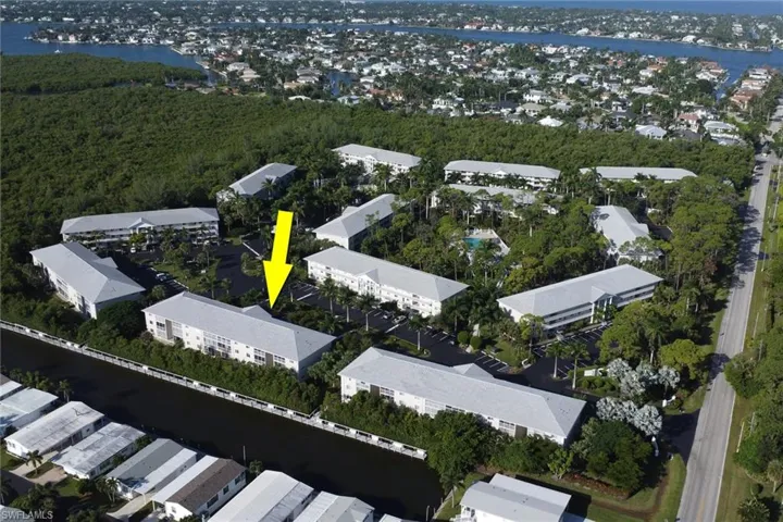 Aerial view of property's location with a nearby body of water and nearby suburban area