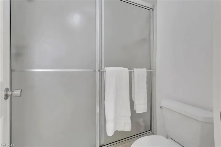 Bathroom with a shower stall and toilet