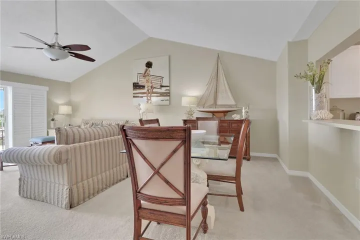 Carpeted dining space with lofted ceiling and a ceiling fan