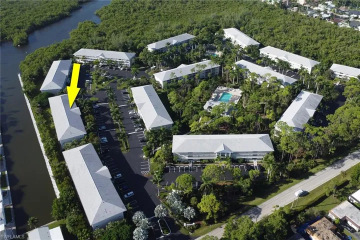 Aerial overview of property's location with a nearby body of water and a heavily wooded area