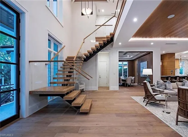 Photos are of a similar home by builder and are for illustrative purposes only. Entrance foyer with light wood-type flooring, floating stairway, recessed lighting, and a towering ceiling.