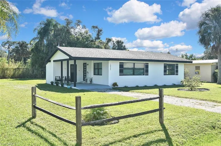 Charming ranch-style home featuring a rustic split-rail fence at each front corner.