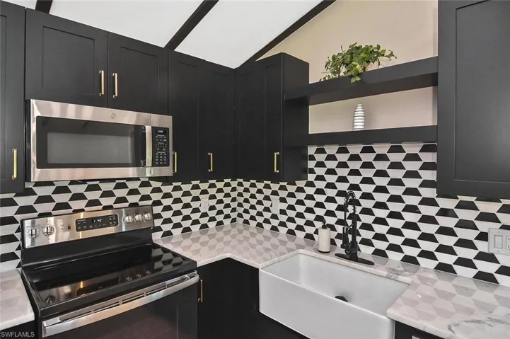 Oversized white undermount farm-style sink with deep bronze fixtures.