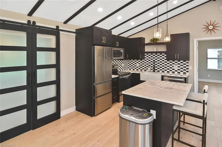 Frosted-glass rolling barn-style doors close off the second bedroom, while adding to the visual symmetry of the kitchen.