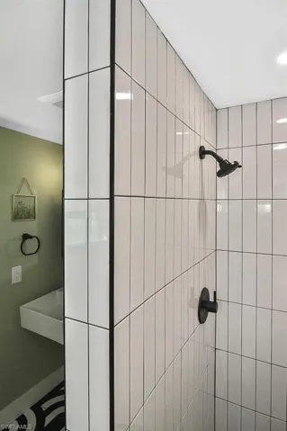Generously-sized walk-in shower in black and white tile.